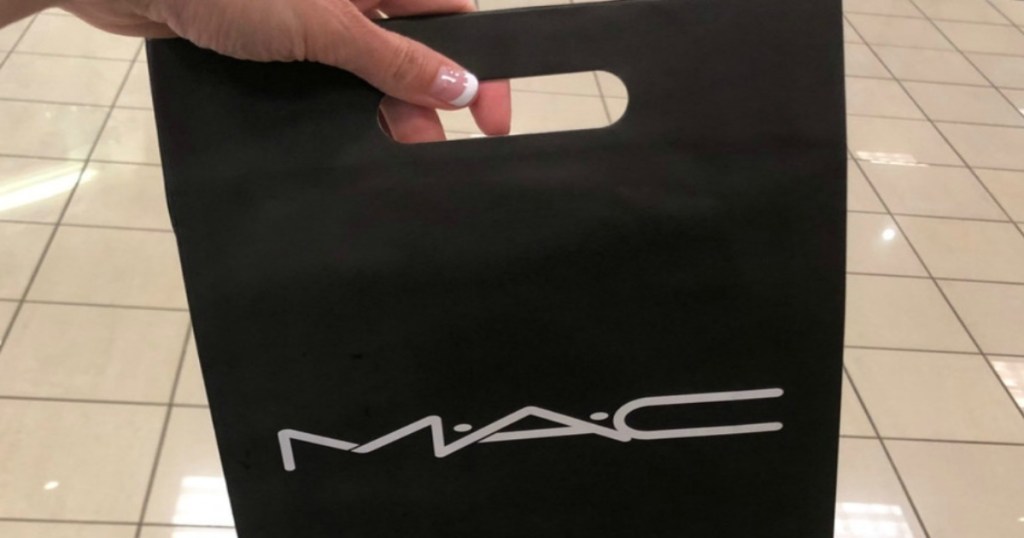 hand holding a black Mac Cosmetics bag