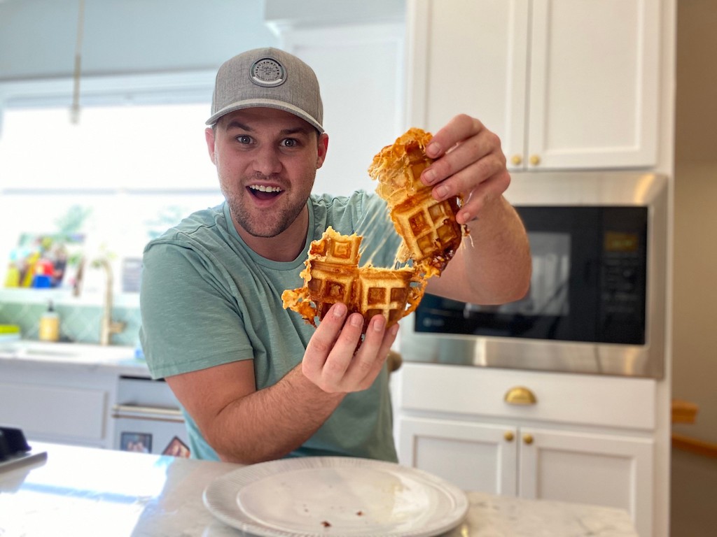man pulling apart waffle grilled cheese 