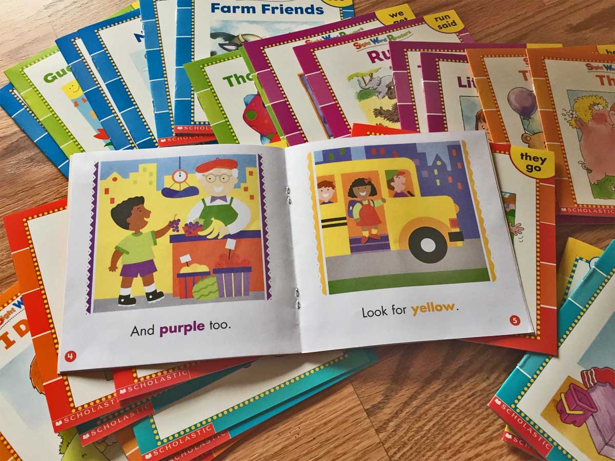 open book on stack of sight word books on table