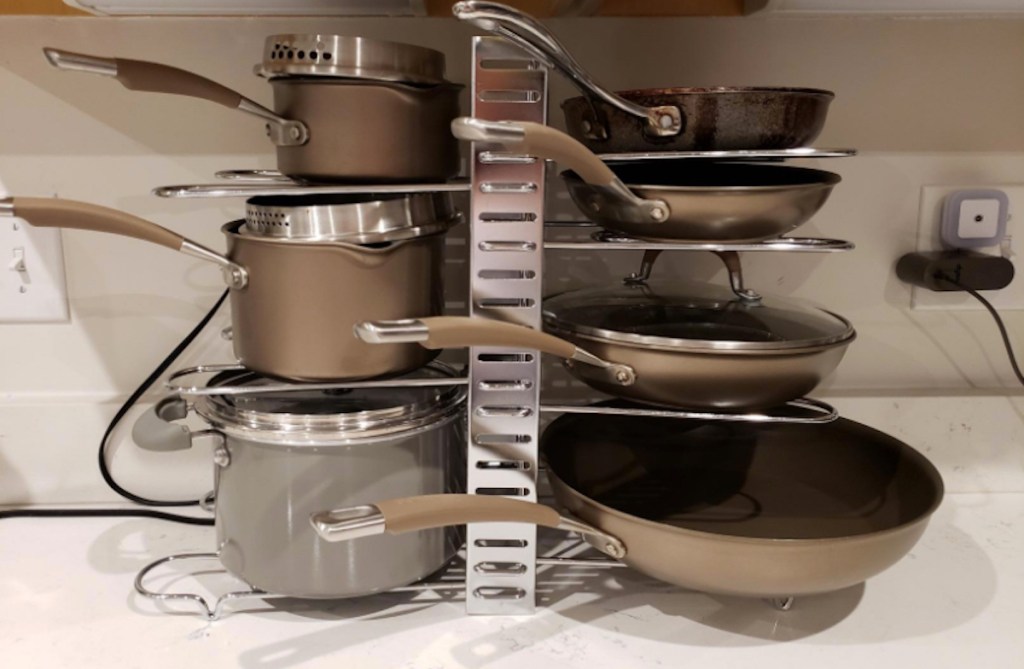 organized pots and pans with lids stacked on metal organizer