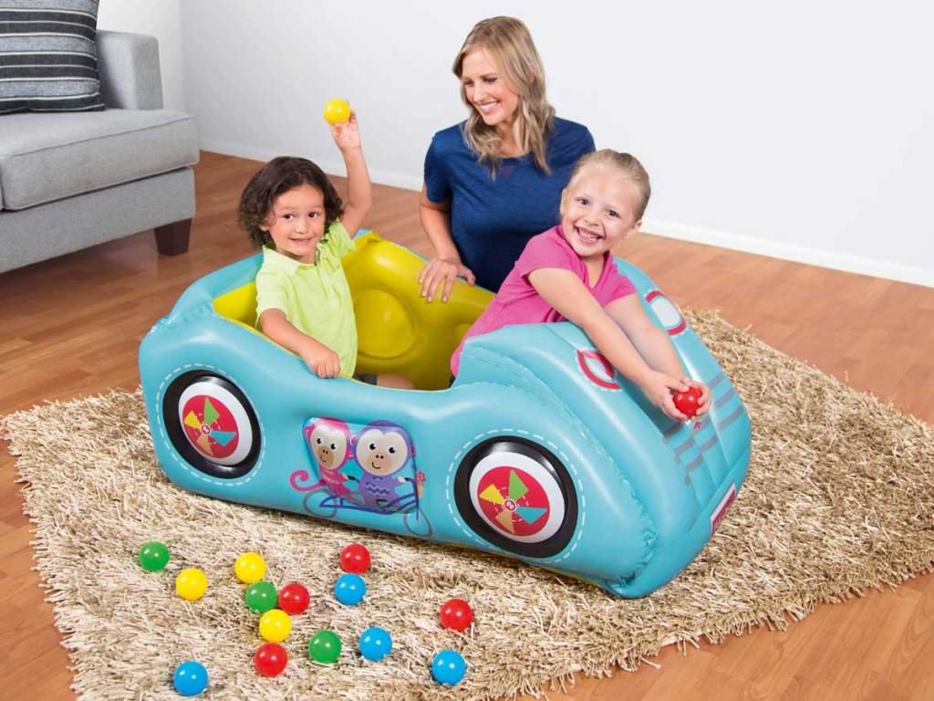 mom playing with kids in a race car ball pit