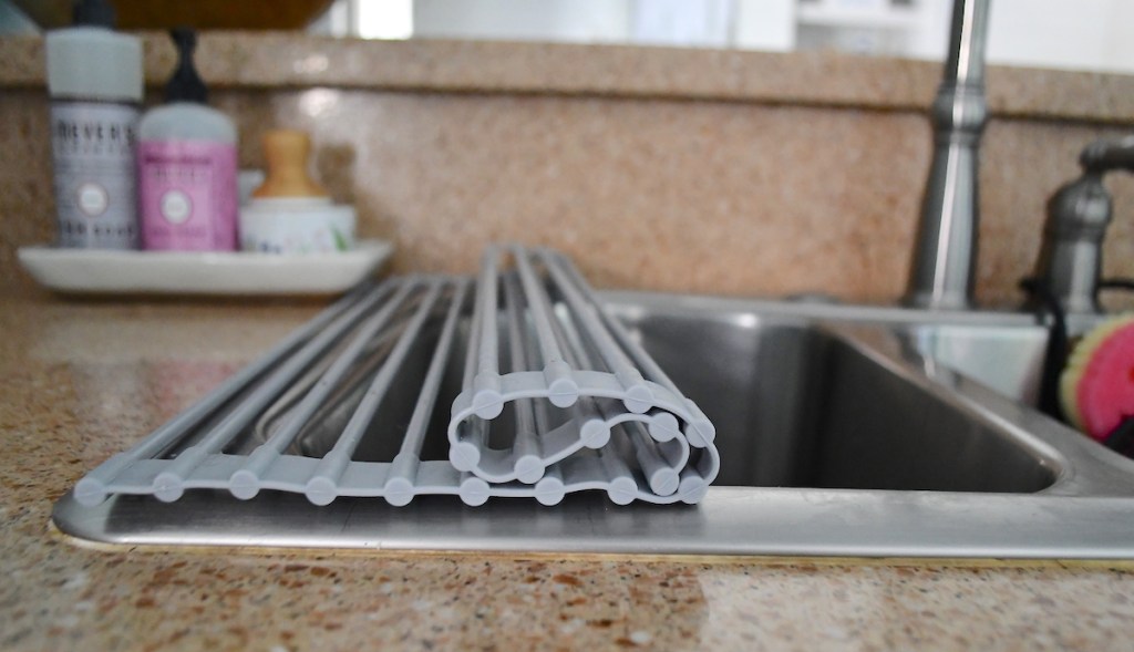 space saving silicone roll up drying rack over top of sink