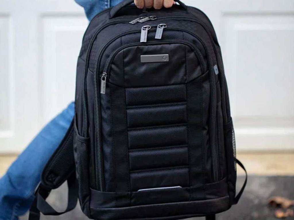man holding a black backpack
