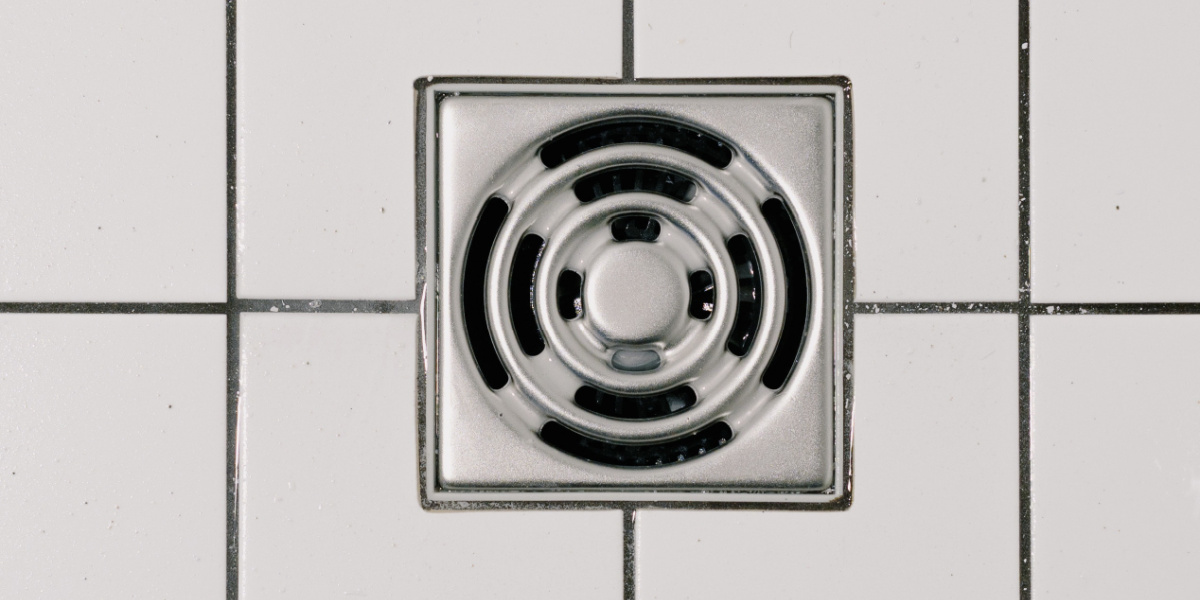 shower drain in a tiled bathroom floor