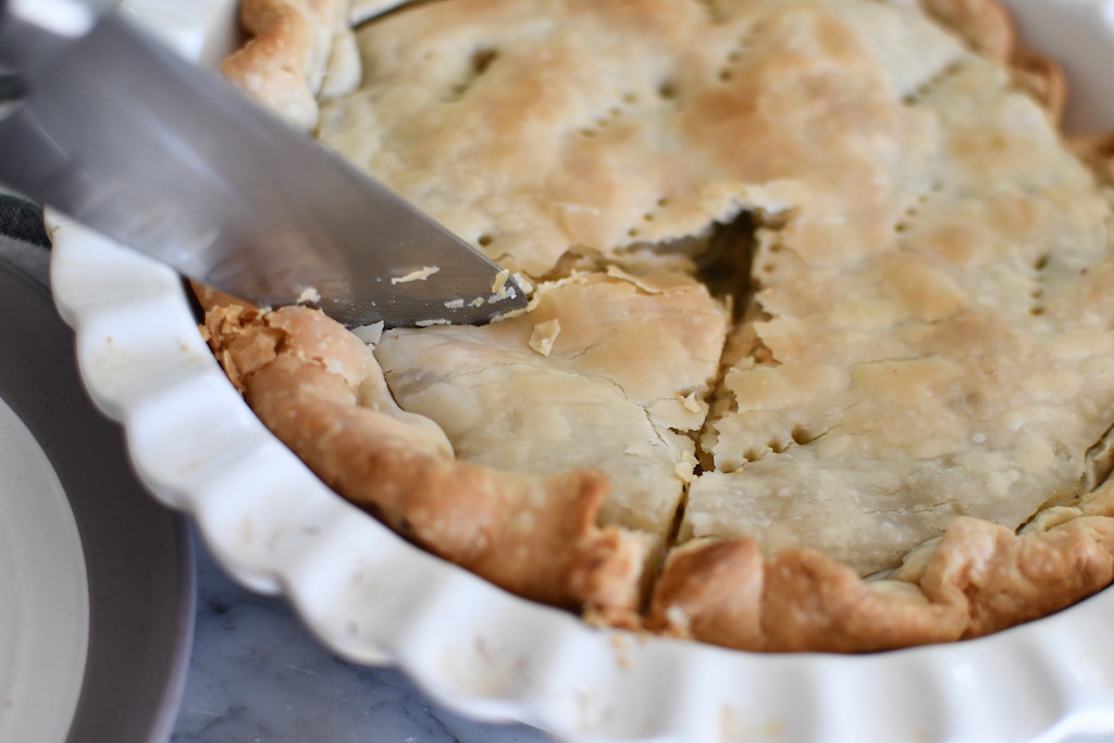 slicing chicken pot pie with knife 