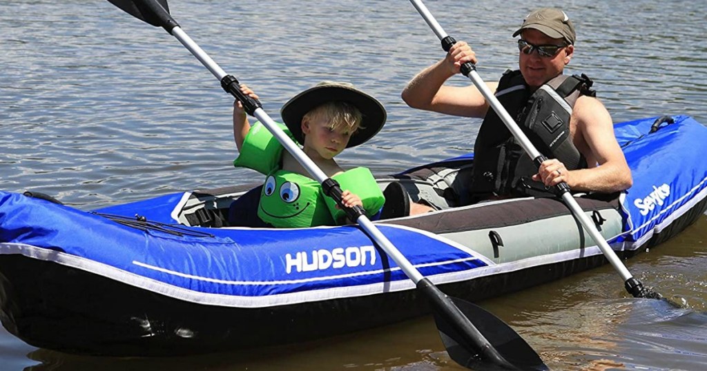 boy and father in kayak on river