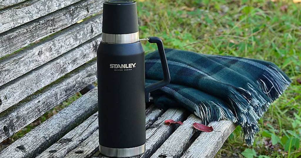 stanley water bottle in black on a park bench