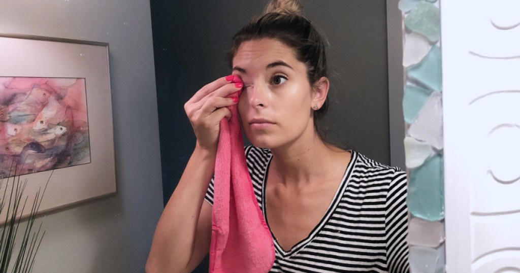 emily using the original makeup eraser used to remove eye makeup in bathroom