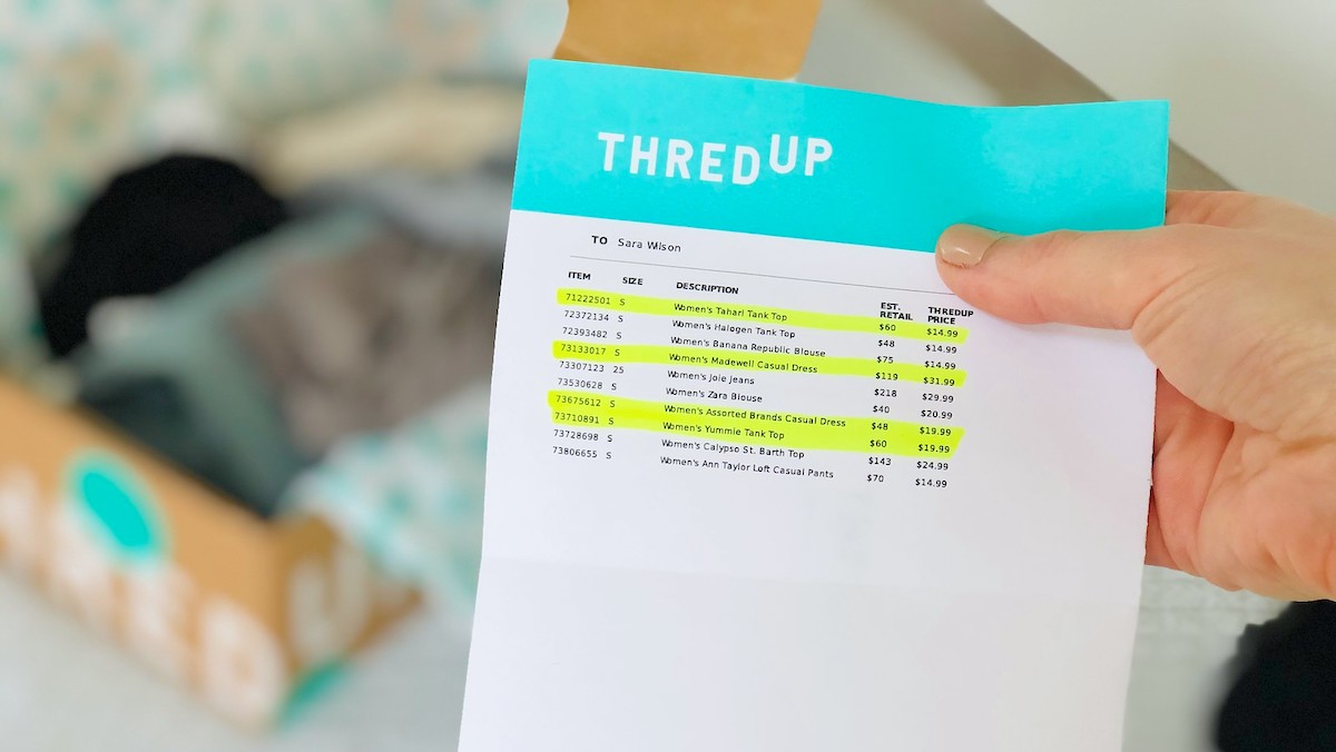 hand holding a blue and white paper thredup receipt with words highlighted