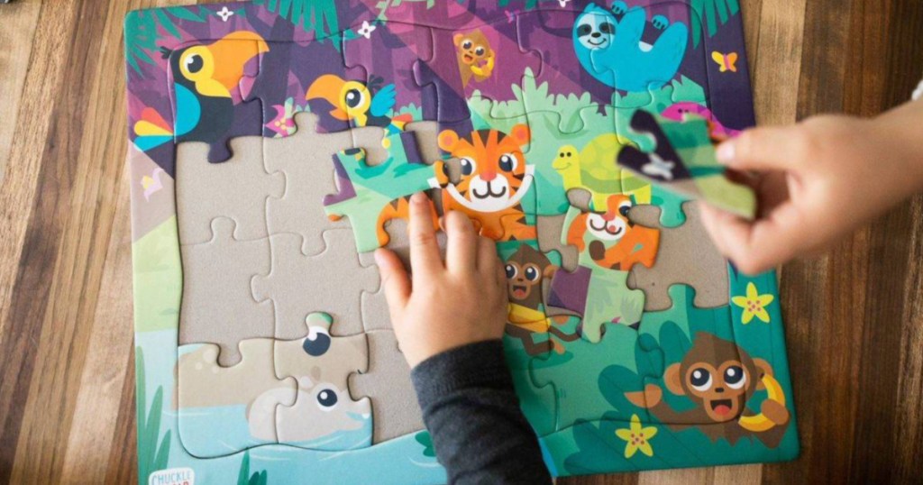 kids hand putting animal puzzle together