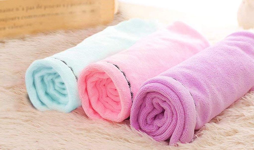 blue pink and purple towels rolled and laying on fur blanket
