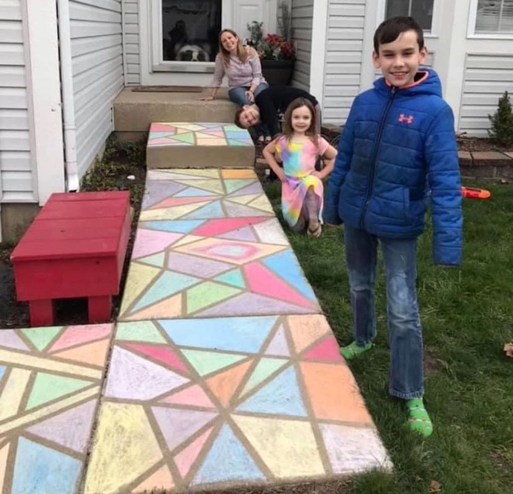 kids outside standing in front of colorful chalk art