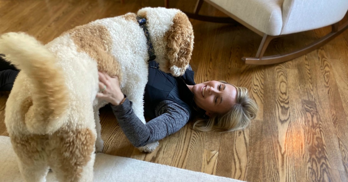 woman laying on floor with dog 
