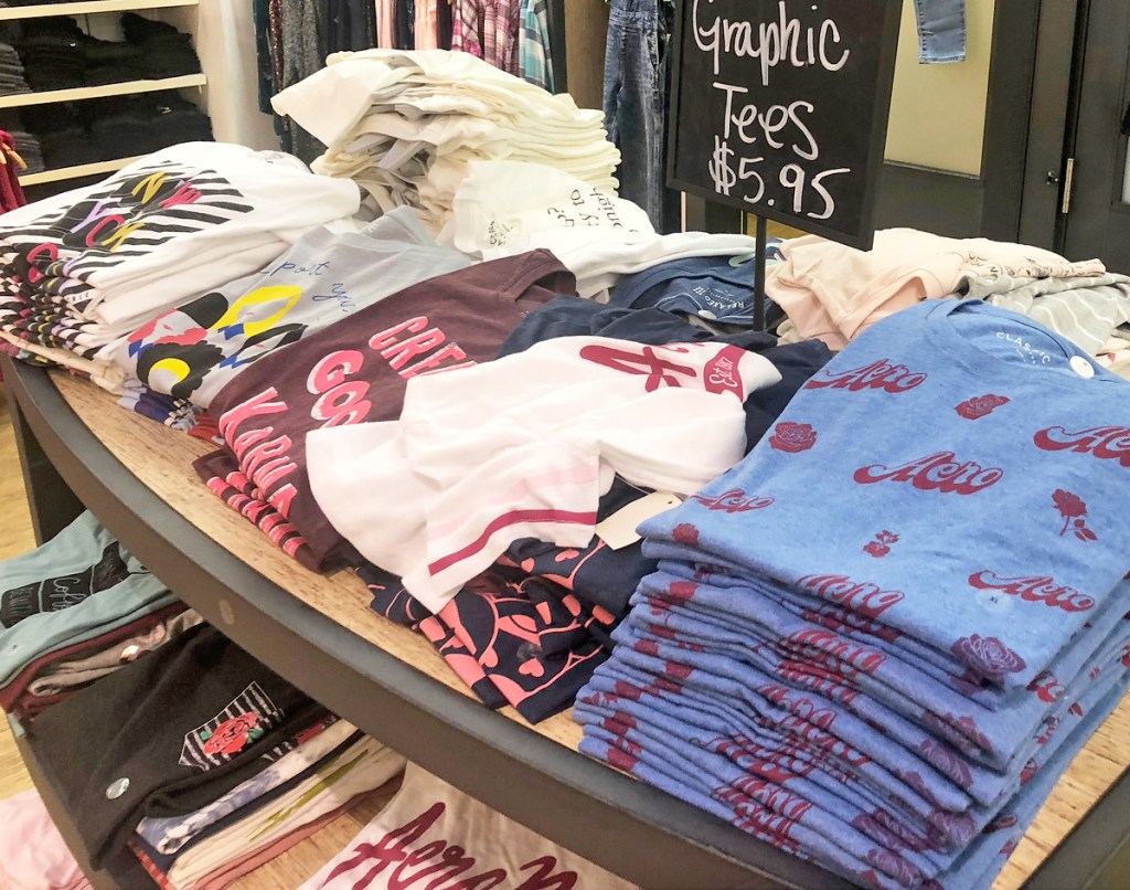 store display table full of various colors of graphic tees