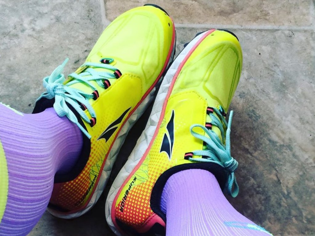 women's yellow and pink running shoes and purple socks