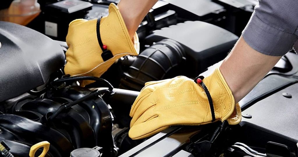 man wearing leather gloves to work on car