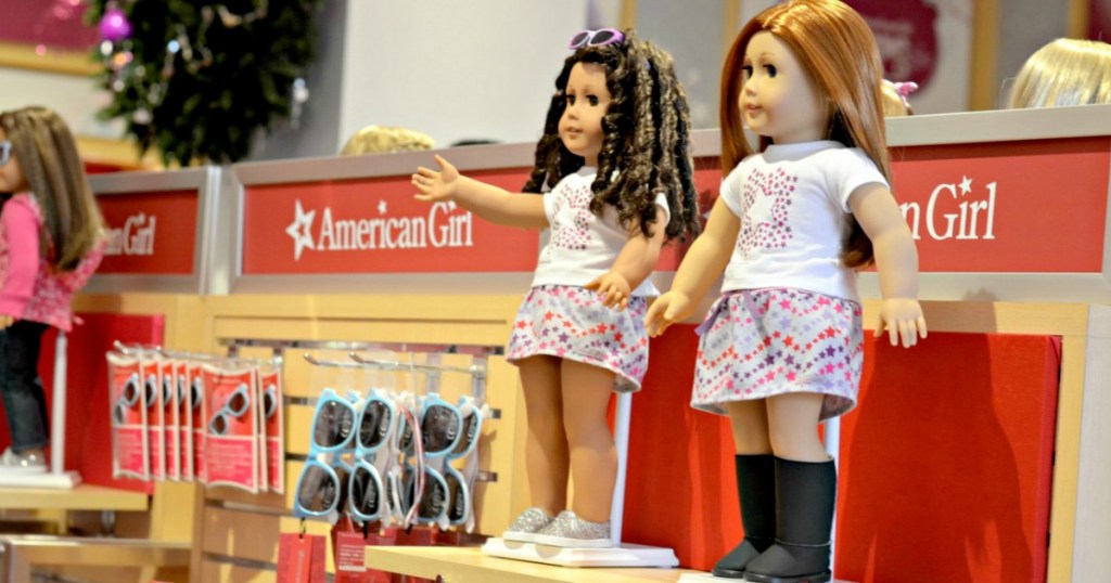 two american girl dolls on store display shelf at american girl store