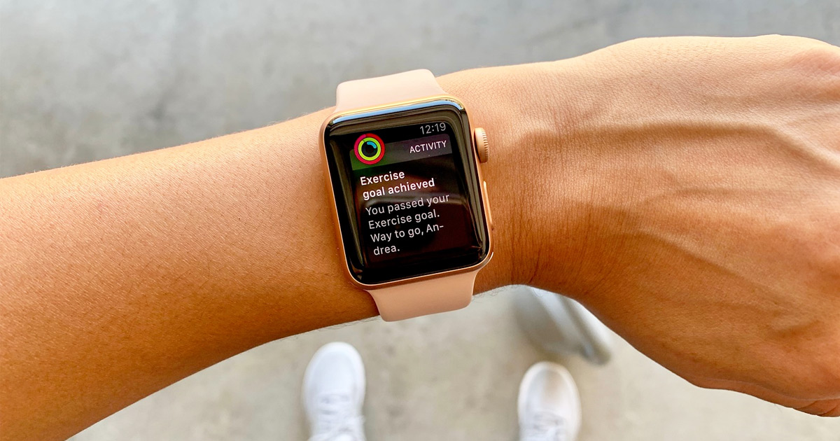 woman holding up her arm showing apple watch screen during workout