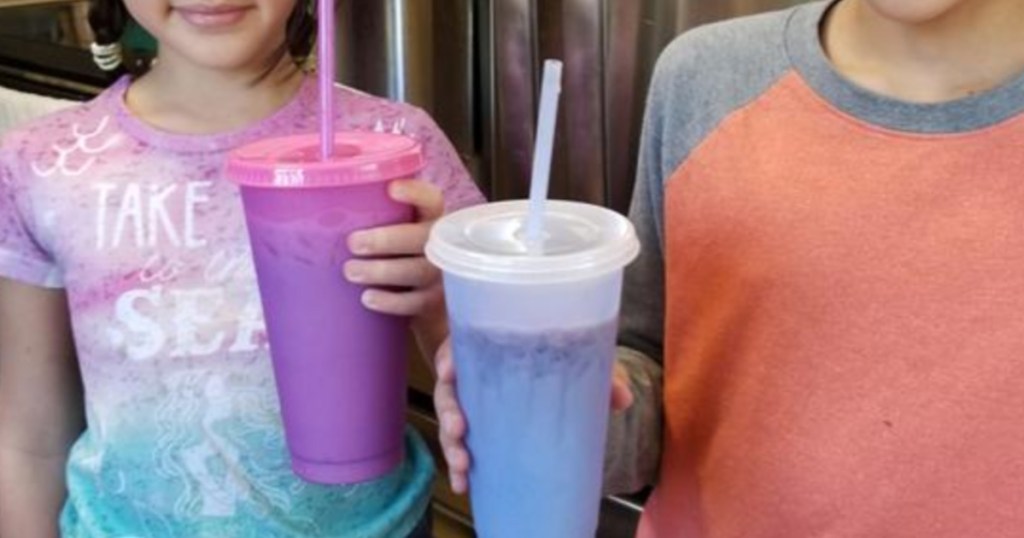 two kids holding color changing tumblers with liquid in them