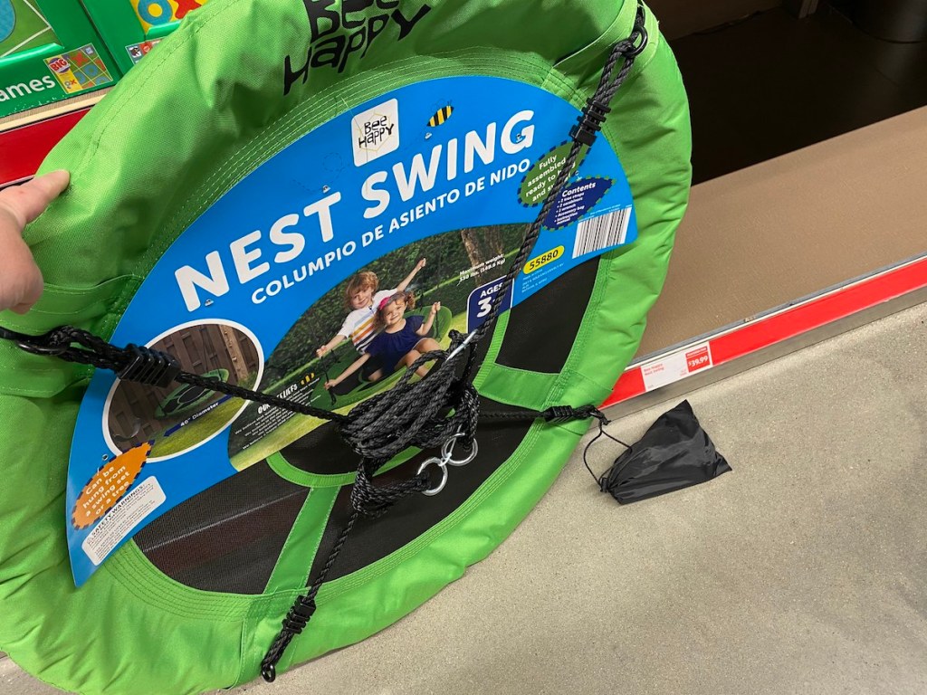 hand holding a green circle swing in packaging near store shelf