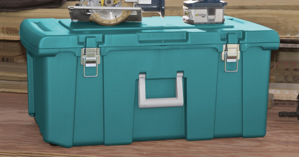 teal colored plastic storage trunk with silver handle and power tools sitting on top of lid