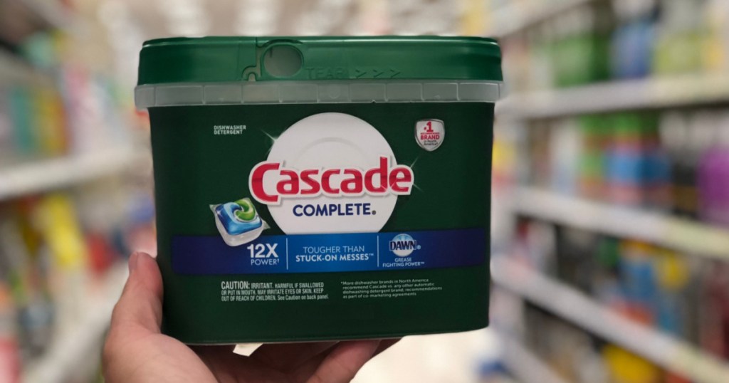 hand holding tub of dish detergent pacs in store aisle
