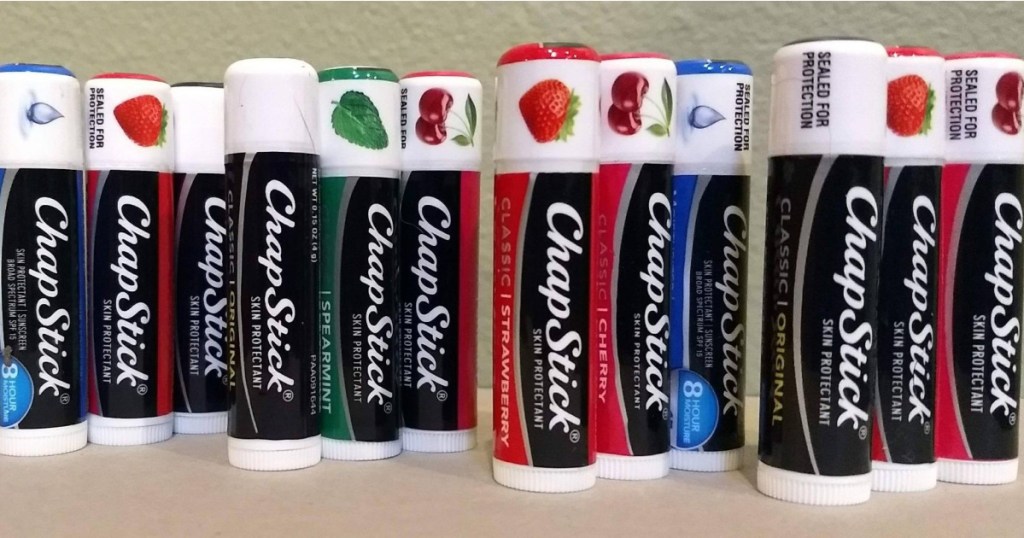 various flavored chapsticks standing up in line on table
