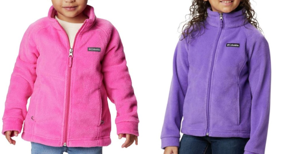 two little girls standing next to each other wearing pink and purple fleece jackets