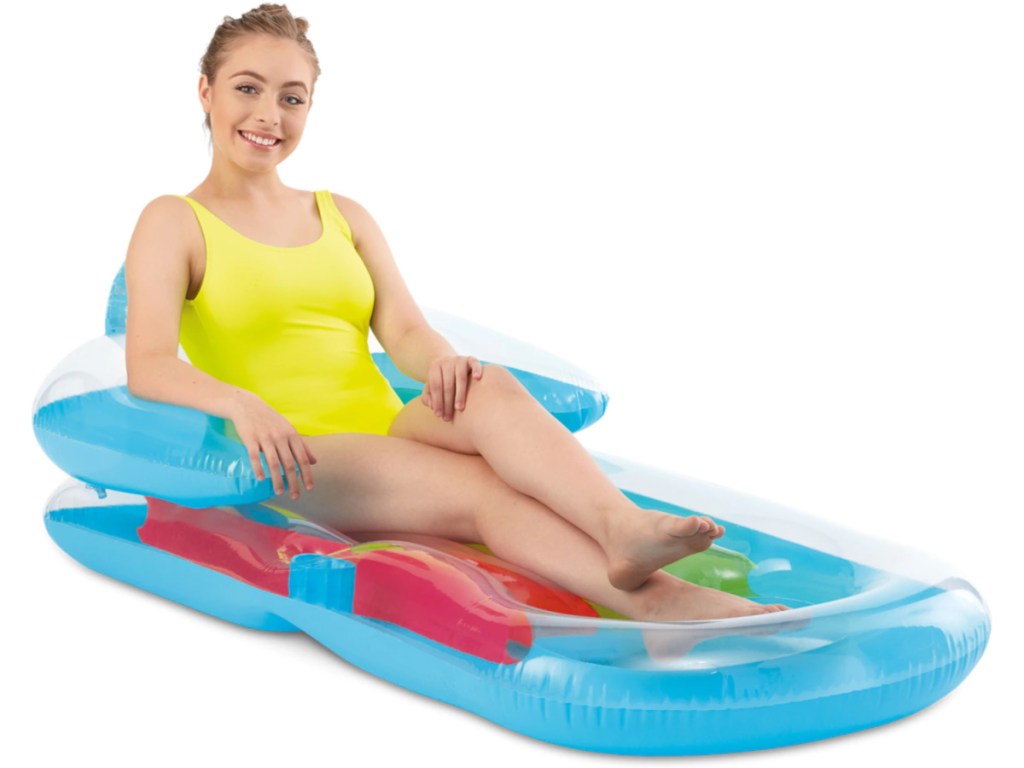 woman in yellow one-piece bathing suit sitting in multi-colored pool float