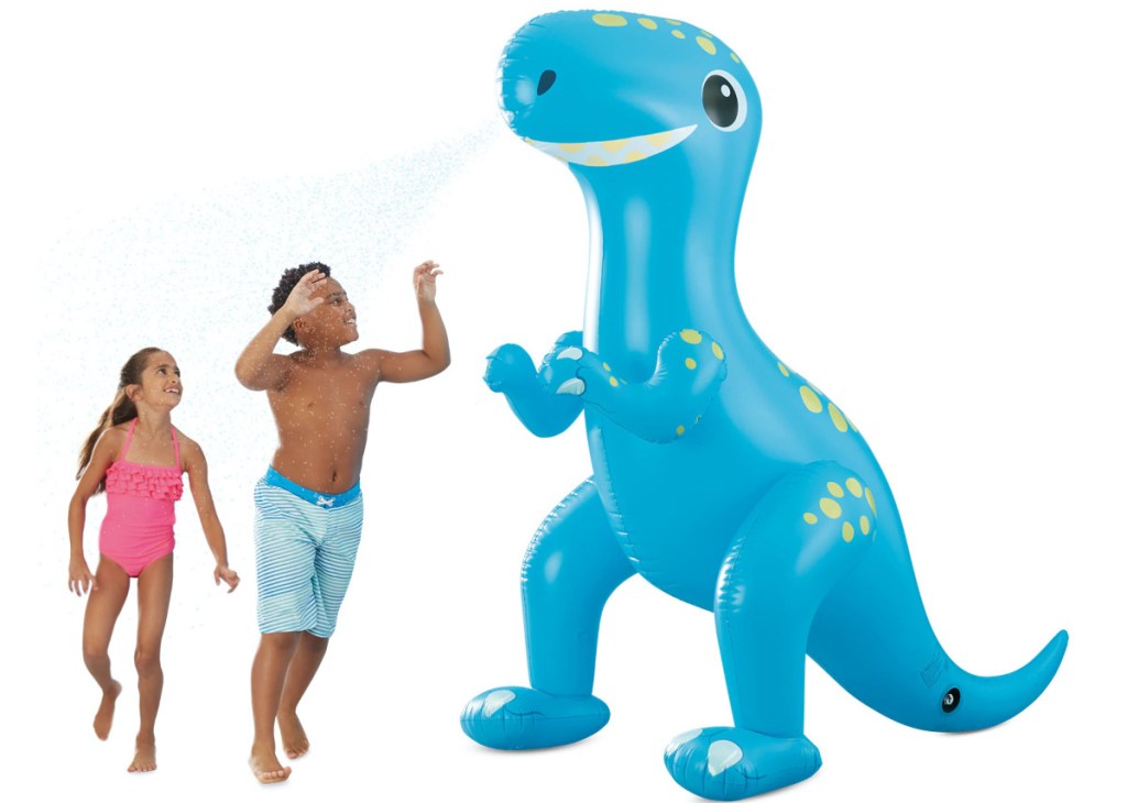 girl and boy in bathing suits running through giant blue inflatable dinosaur sprinkler