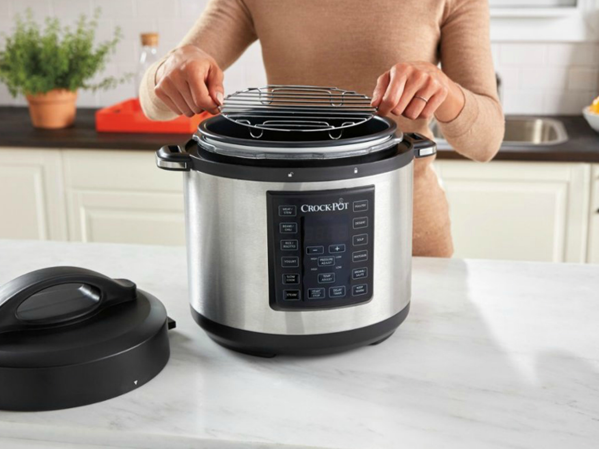 Woman placing a cooking rack into a pressure cooker on a kitchen counter