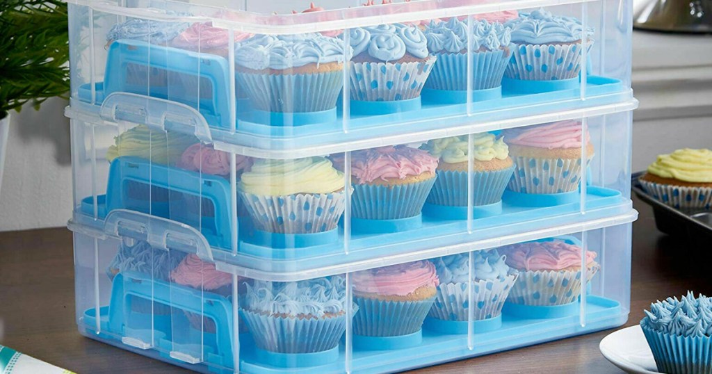 blue plastic cupcake carrier filled with cupcakes sitting on kitchen table