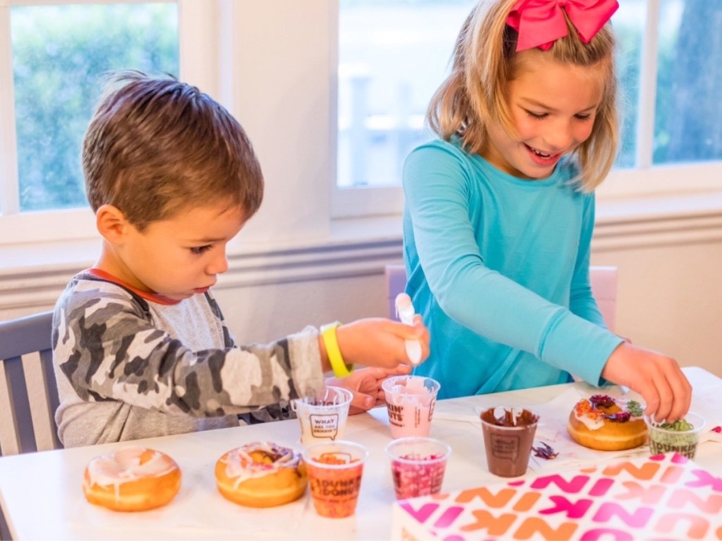 kids using DIY donut kit at table in home