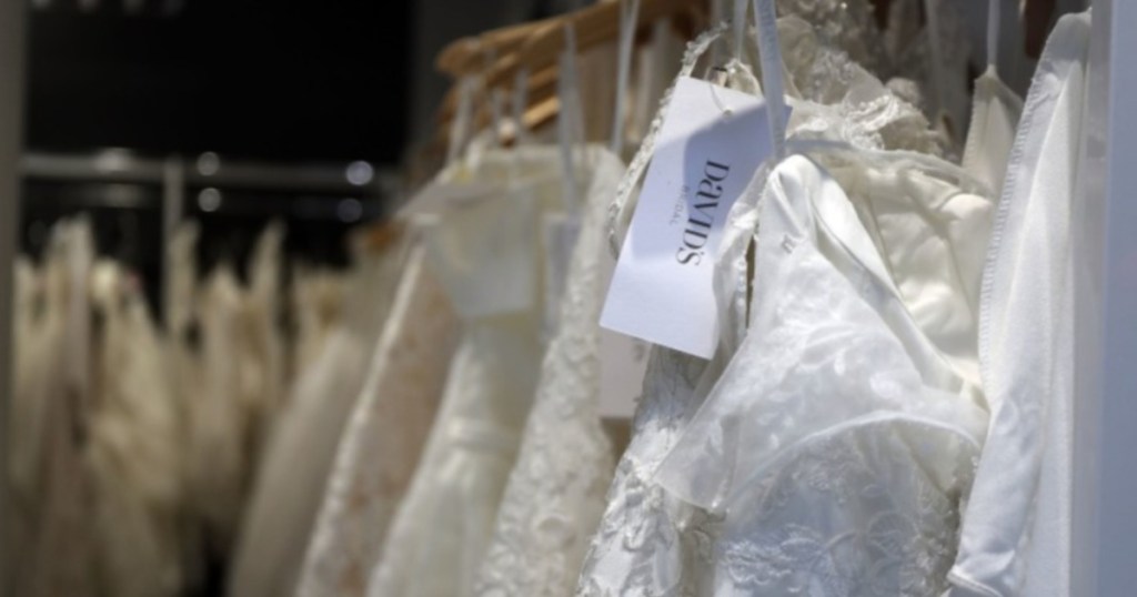 David's bridal wedding dresses hanging on a rack