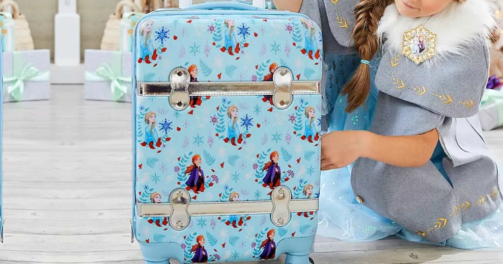 Girl holding Frozen themed hardcase luggage