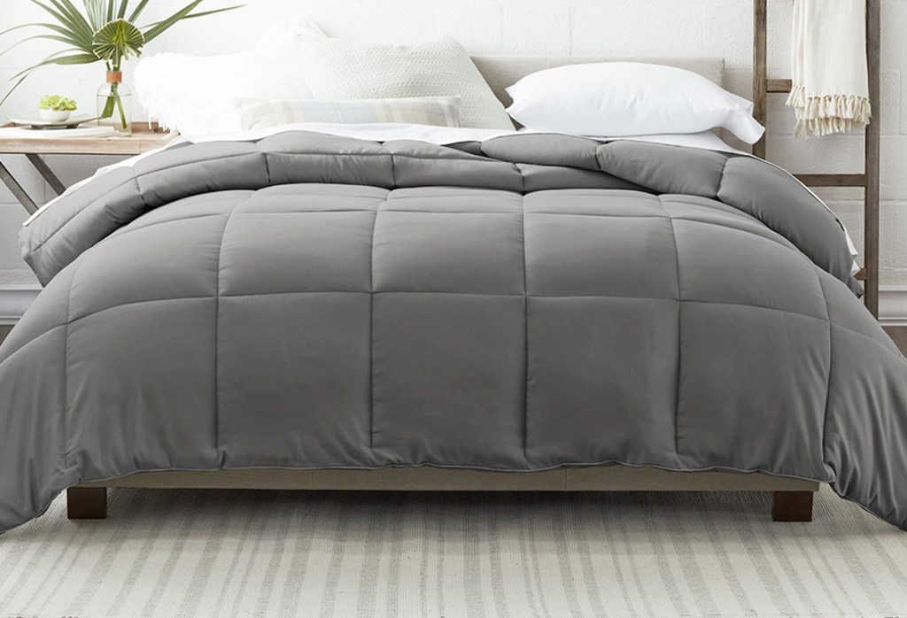 grey comforter with square embossing on bed with white sheets