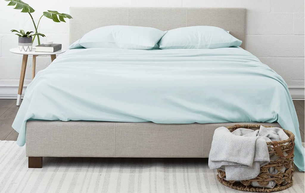 light blue sheet set on bed with grey headboard