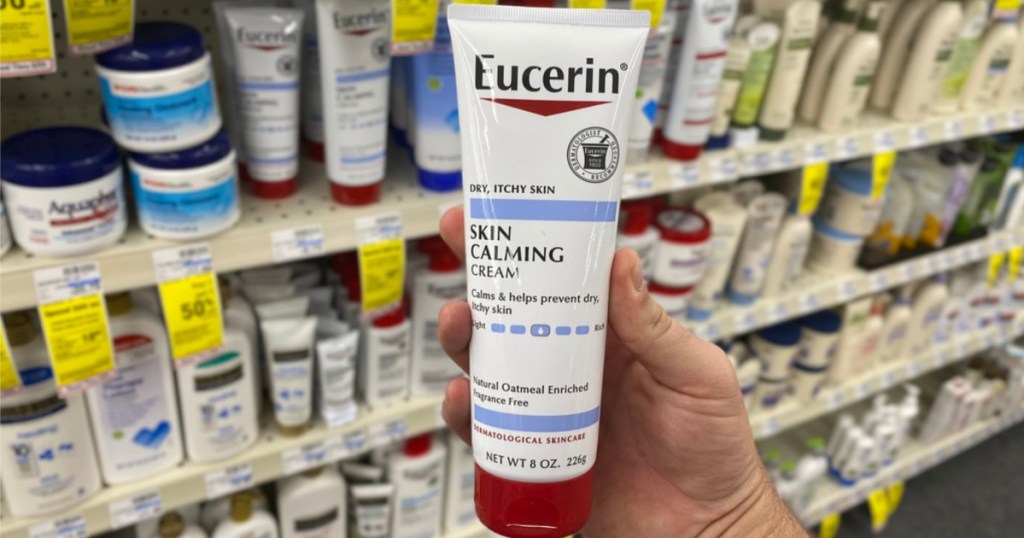 hand holding bottle of skin calming lotion in store aisle