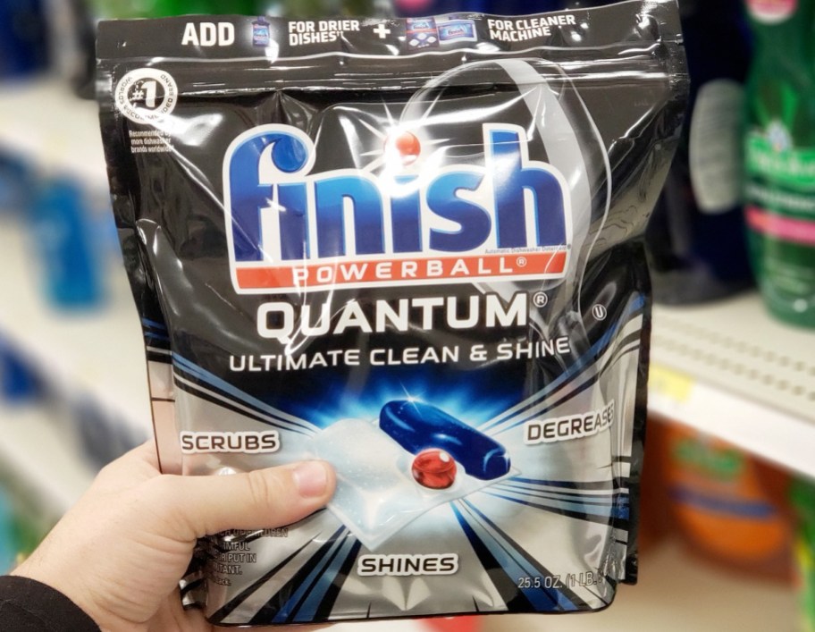 person holding black bag of finish quantum dishwasher tabs