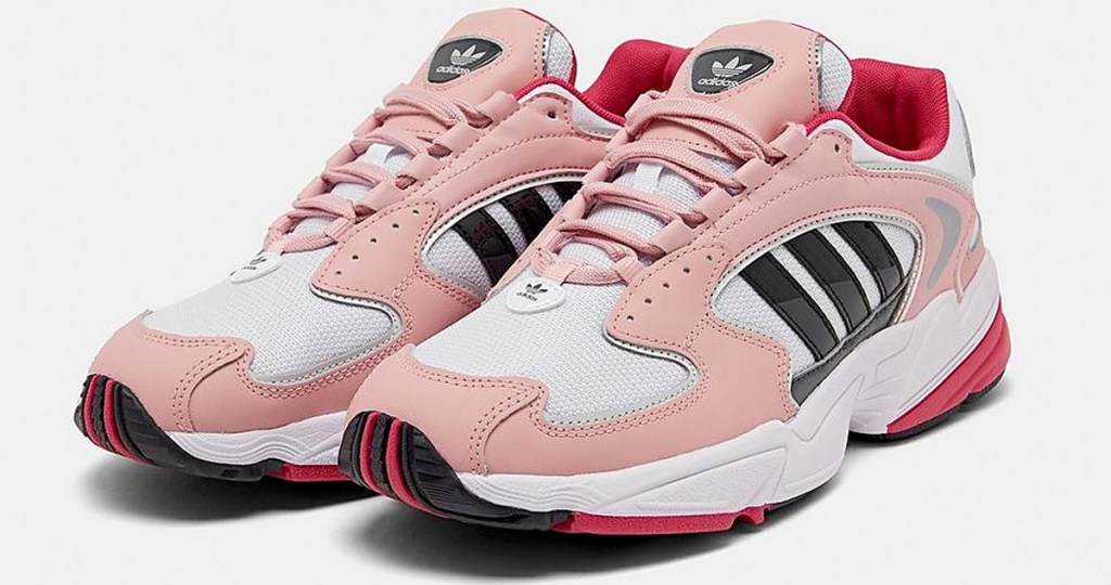 pair of pink and white womens adiads shoes with three black stripes