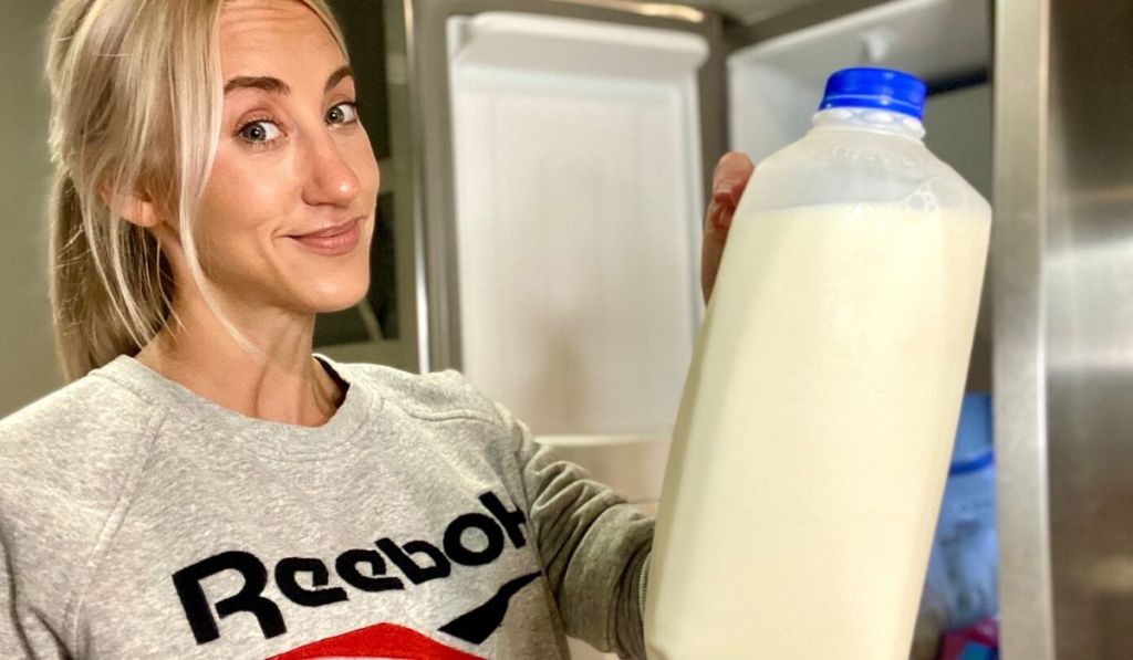 Woman holding a jug of milk to store in the freezer
