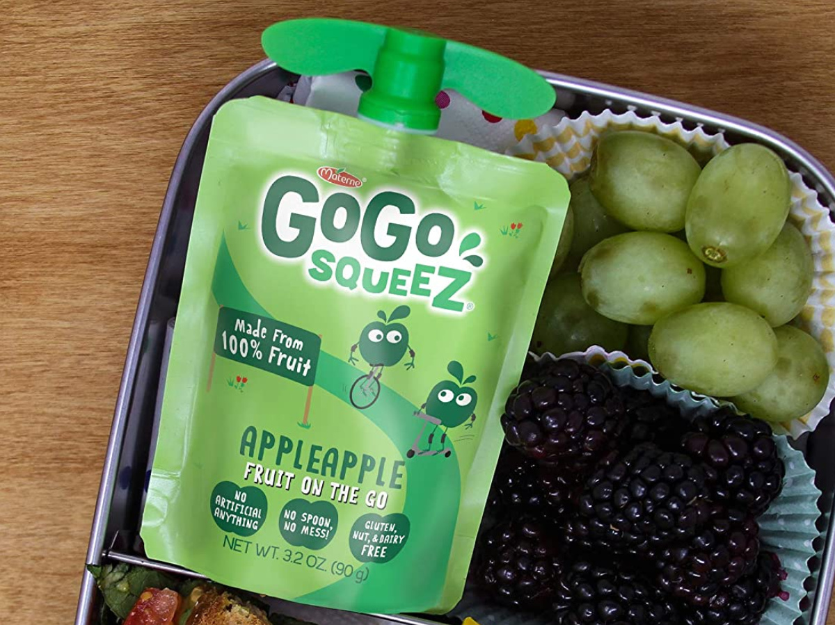 squeezable applesauce pouch in lunch box with green grapes and blackberries
