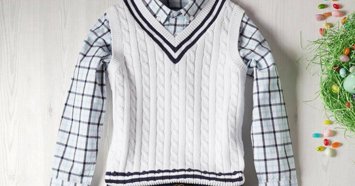 boys white sweater vest and blue button down shirt laid out on grey surface