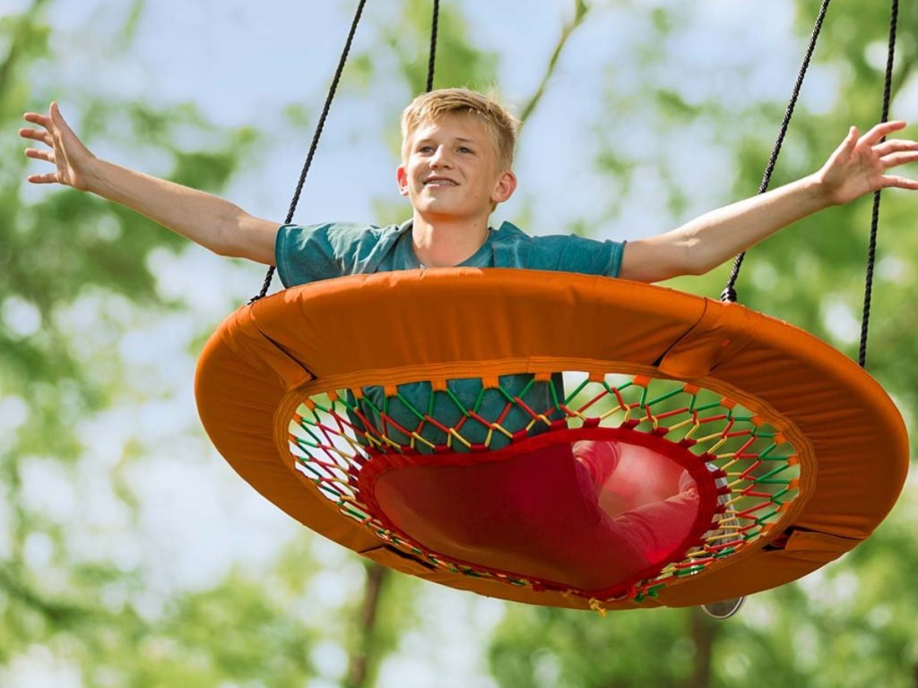boy swinging on his stomach bungee swing outside