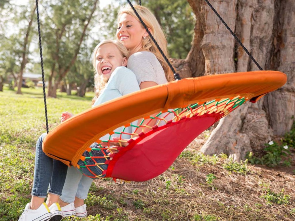 woman and daughter sitting in bungee swing outside