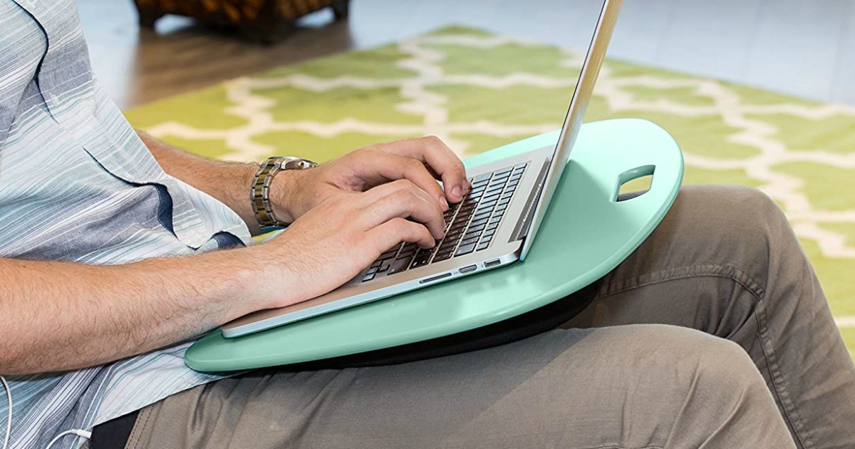 sitting man working on laptop on a laptop desk