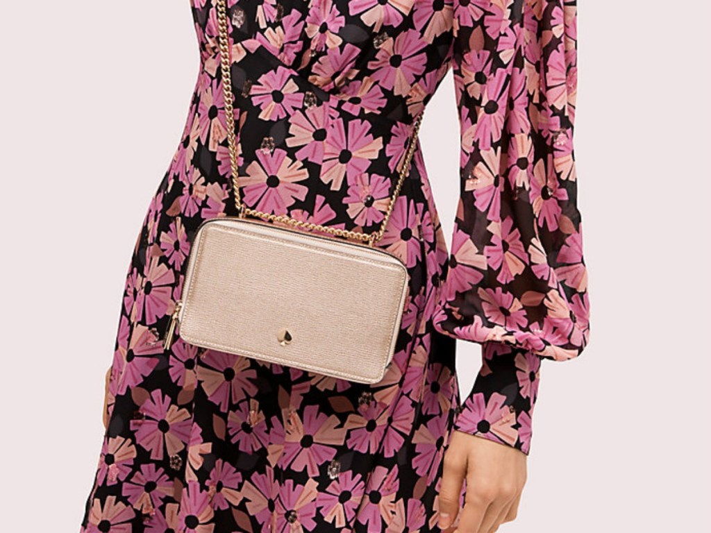 woman in floral dress wearing a gold purse