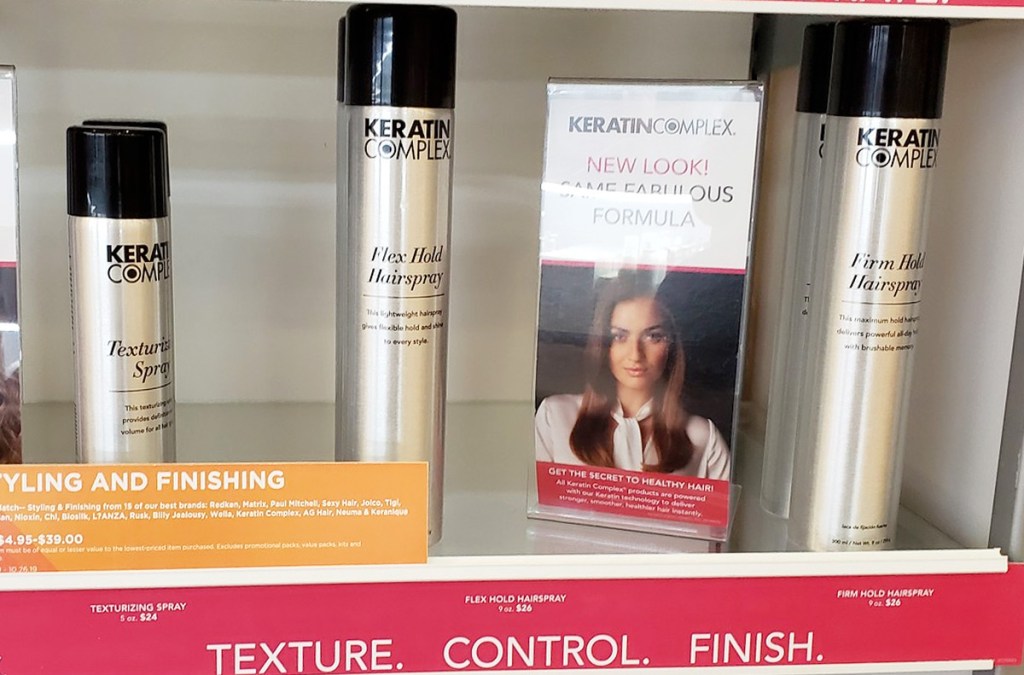 silver bottles of Keratin Complex hairspray on store display shelf