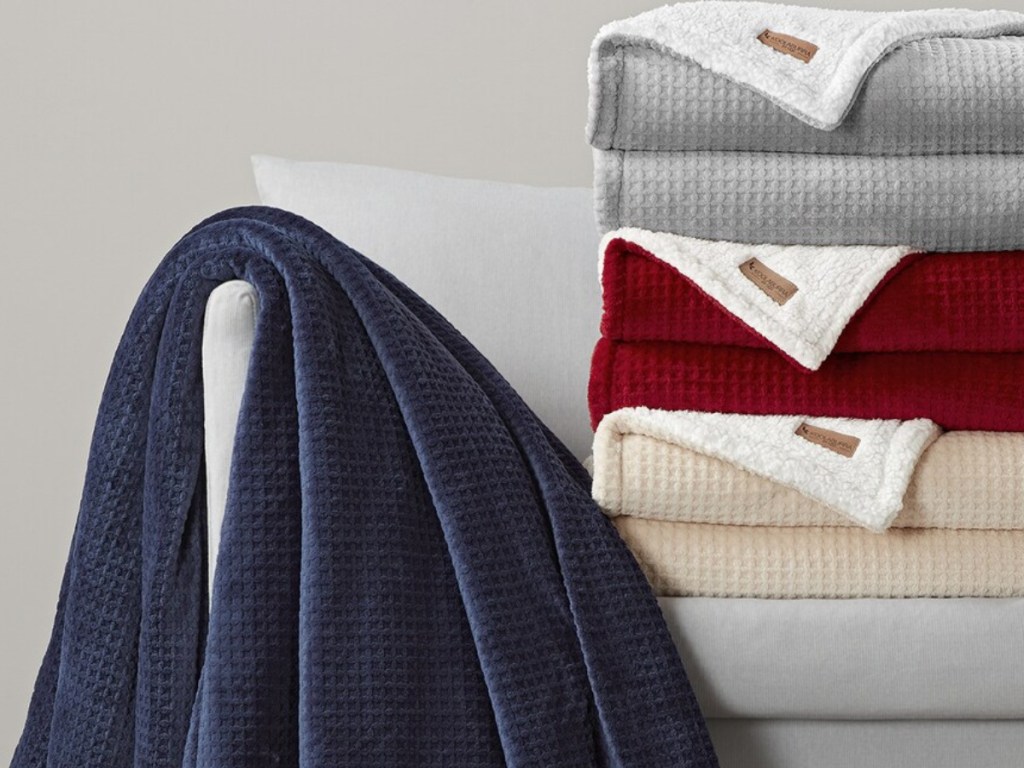 variety of colored throw blankets on gray couch