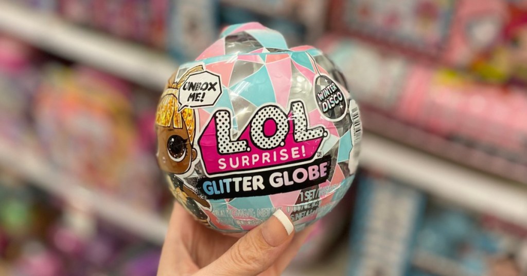 woman's hand holding l.o.l. surprise winter globe ball in store